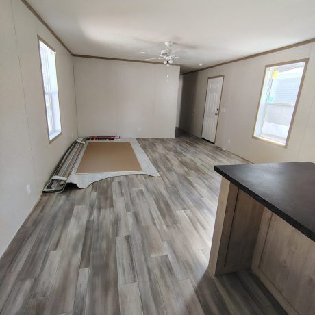 A cozy room featuring polished wood floors and a ceiling fan.